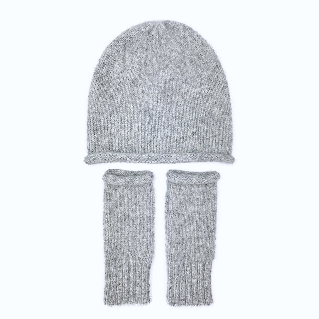 Heather gray slouchy beanie above a pair of matching gray wrist warmers, laid flat on white