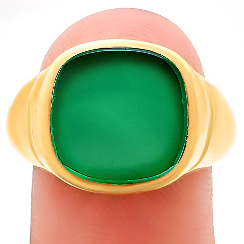 Green onyx signet ring balanced on a fingertip, cushion stone seen straight on