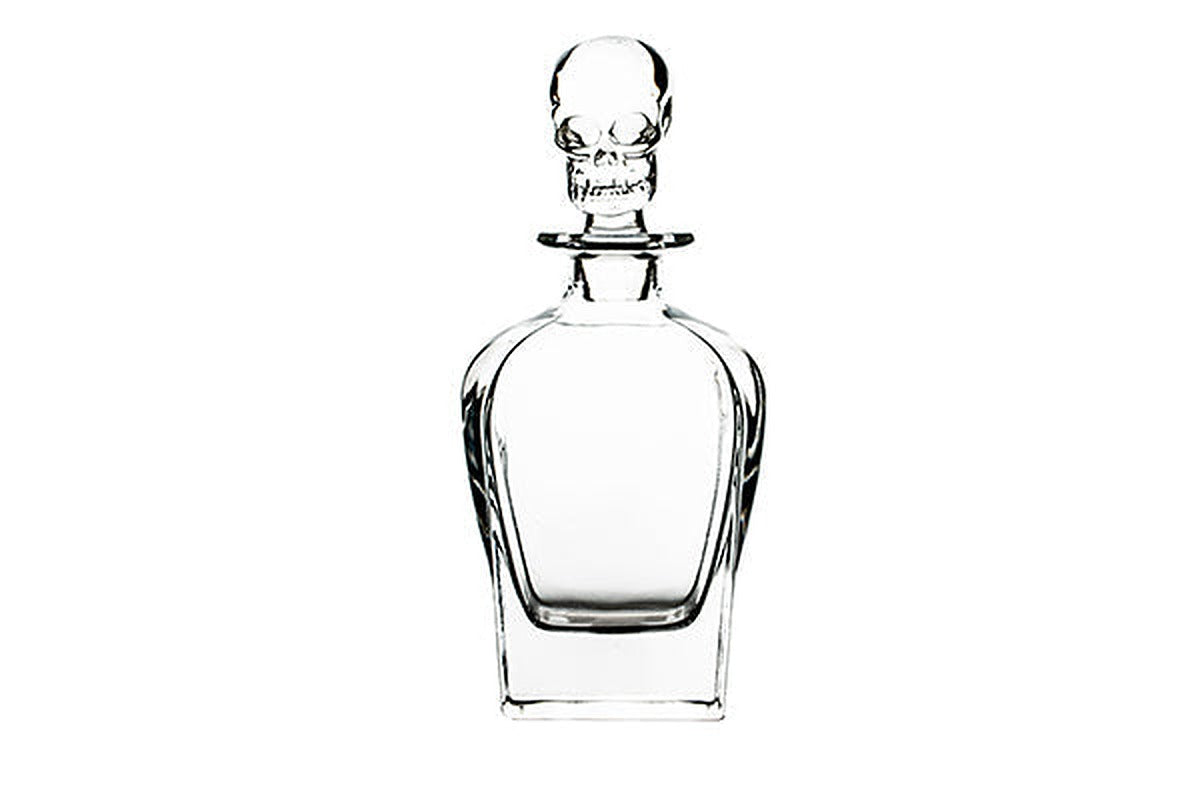 Clear glass spirits decanter with a squared body and a stopper molded as a human skull.