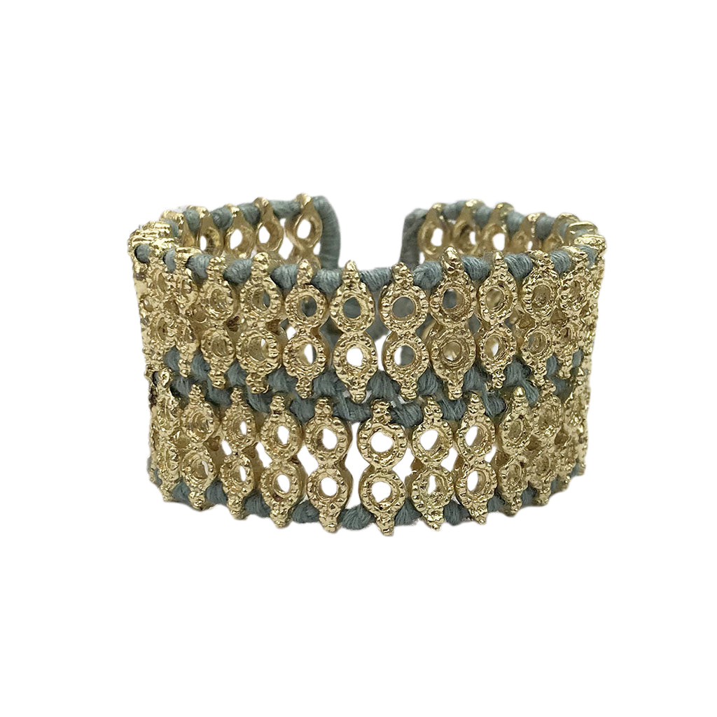Wide woven cuff bracelet with steel blue cotton thread and gold tone beads, front view on white