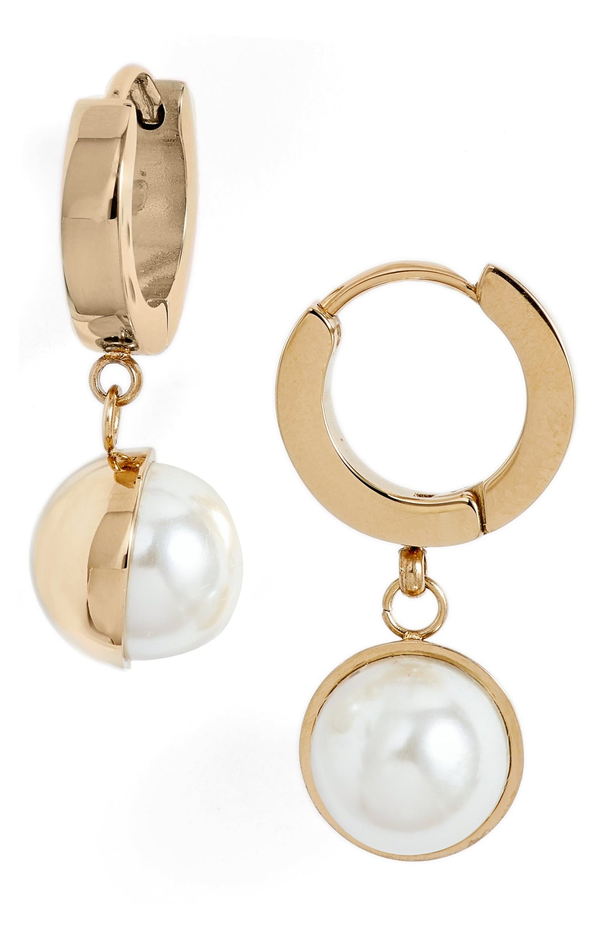 Pearl drop huggie earrings in gold tone stainless steel, one turned to show the faux pearl in its half cup