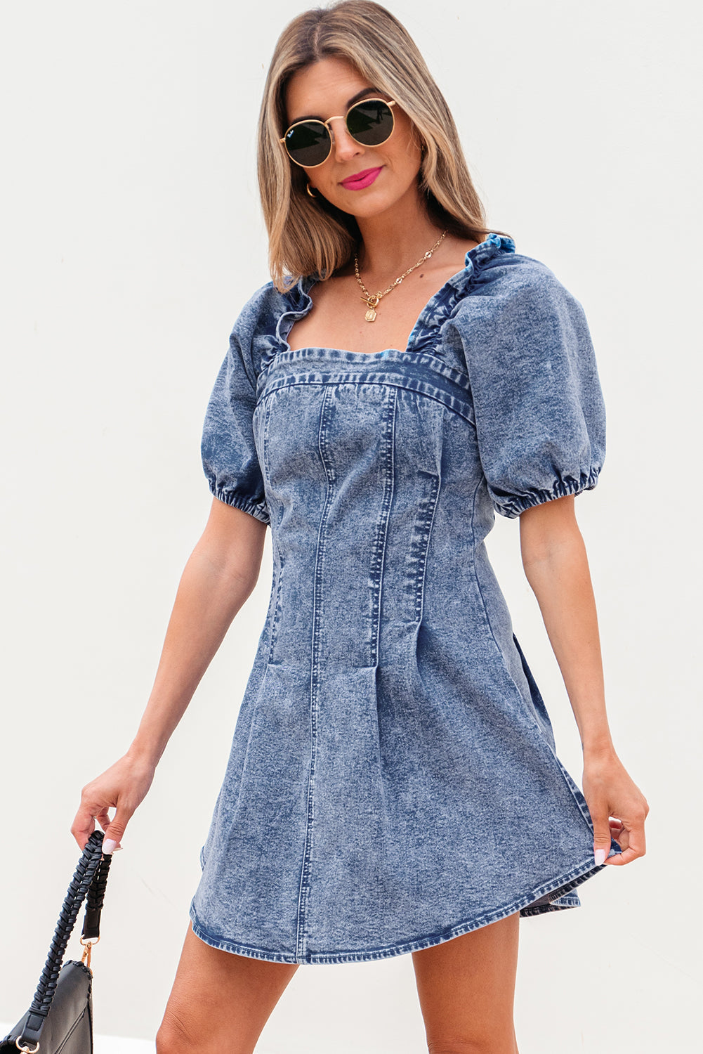 Acid wash puff sleeve denim dress with a black bag, front view