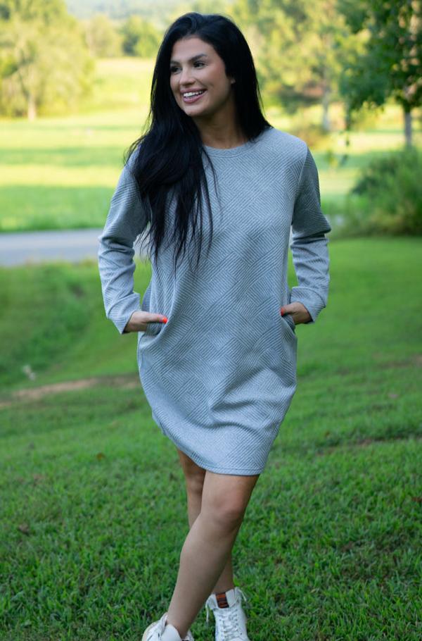 Gray long sleeve shift dress, model walking in white sneakers