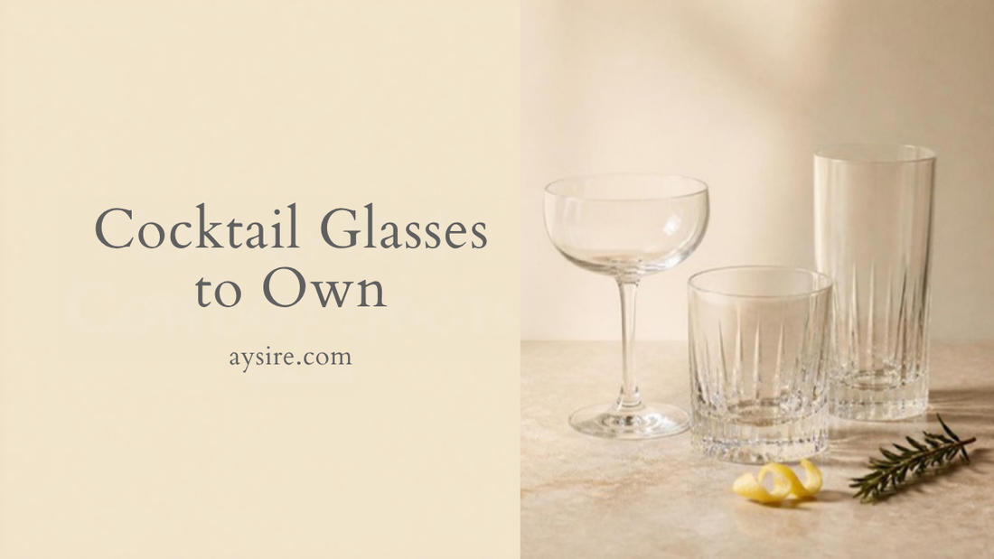 Cocktail Glasses to Own. Empty coupe, rocks and highball glasses on a stone counter with a lemon twist and rosemary.