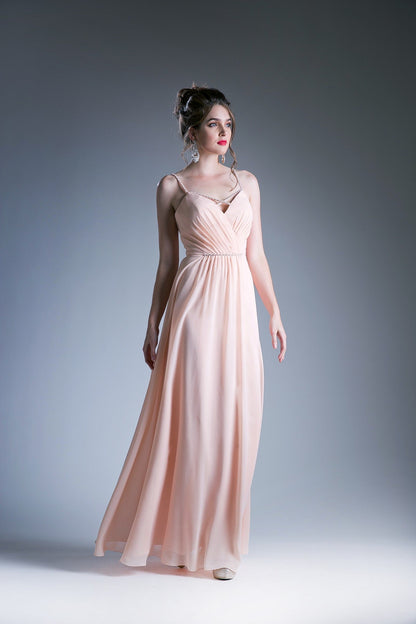 Peach V-neck evening gown with spaghetti straps and a beaded waistband.