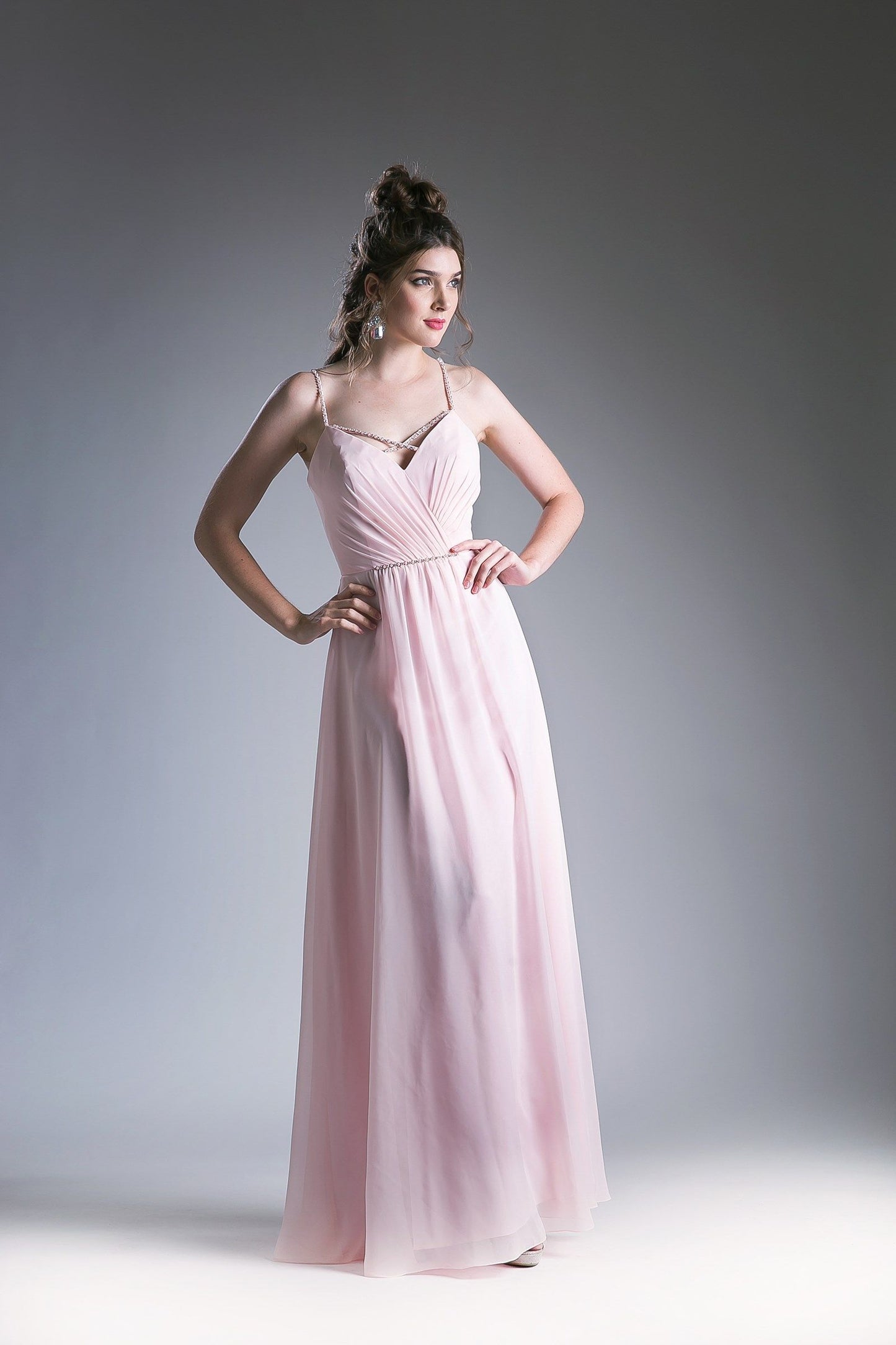 Pink V-neck evening gown with spaghetti straps and a beaded waistband.