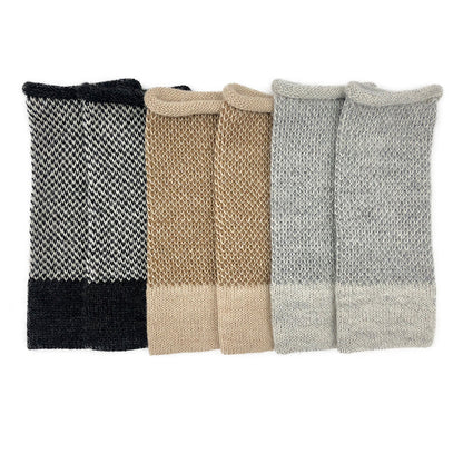 Three pairs of two-tone alpaca fingerless gloves side by side in black and white, camel and gray