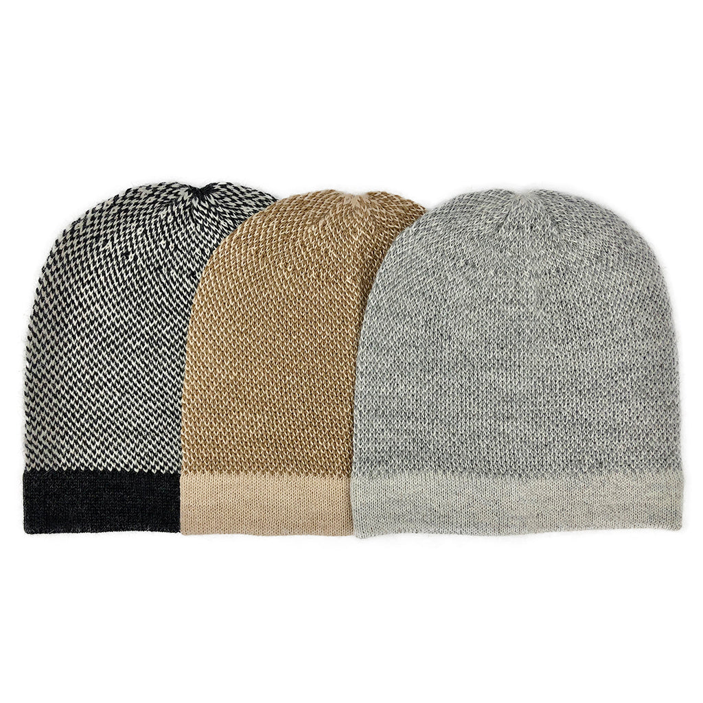 Three two-tone beanies side by side in black and white, tan, and gray