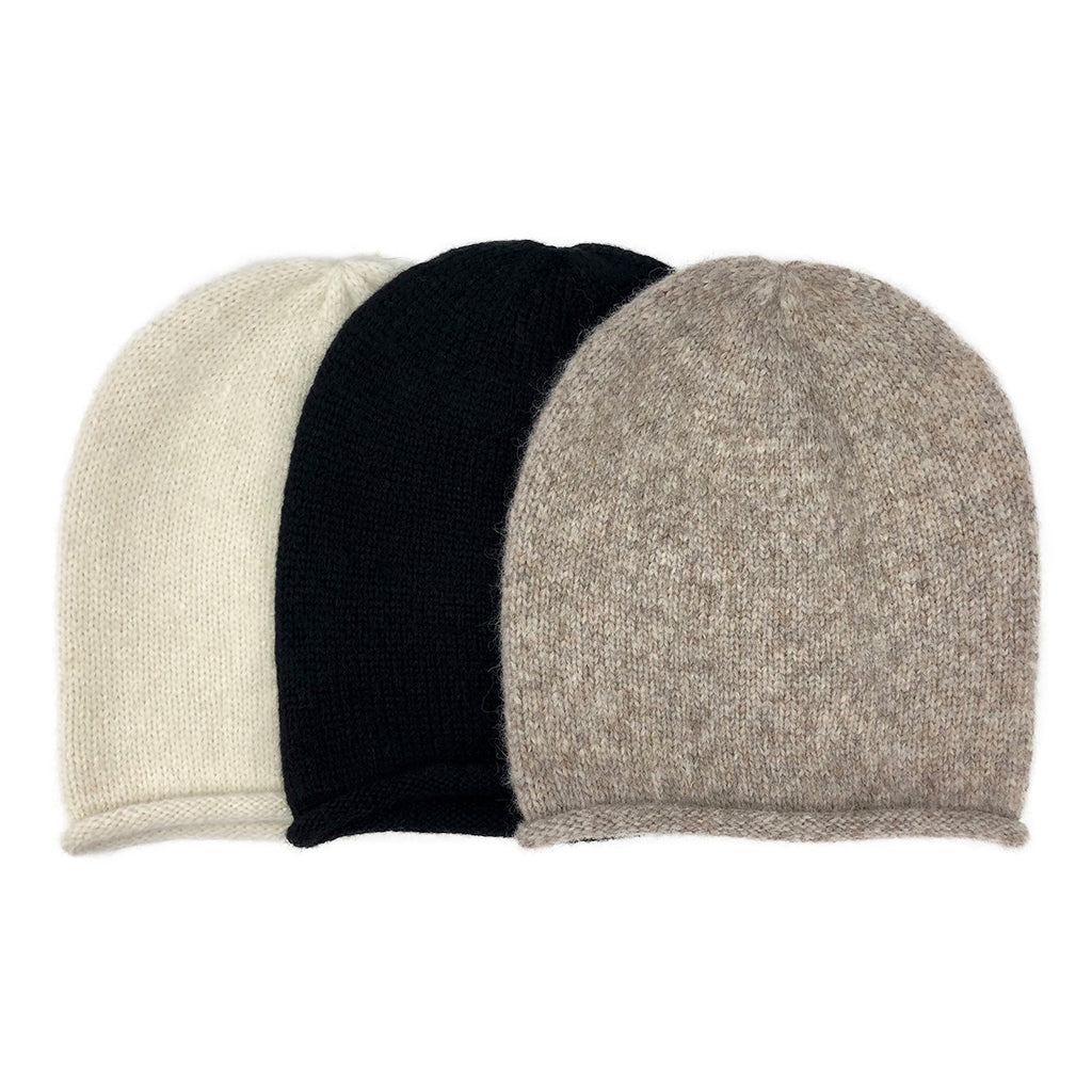 Three beanies side by side in cream, black and beige