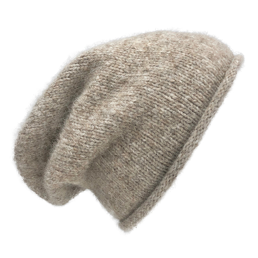Beige slouchy beanie seen from the side, a rolled edge and extra length at the back