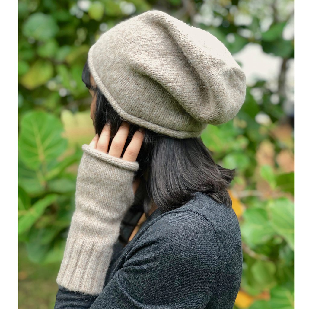 Model in the beige slouchy beanie pushed back off the forehead, with matching fingerless gloves