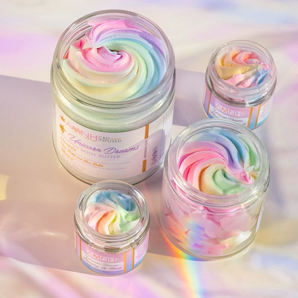 Four open jars of rainbow whipped butter on an iridescent surface.
