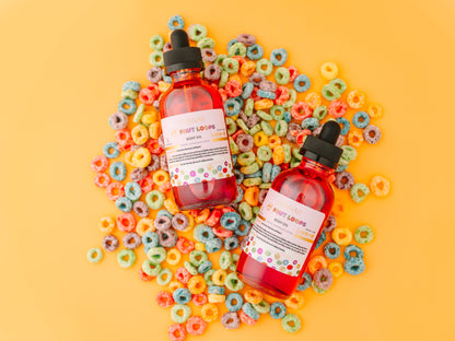 Two body oil bottles lying on scattered cereal loops.