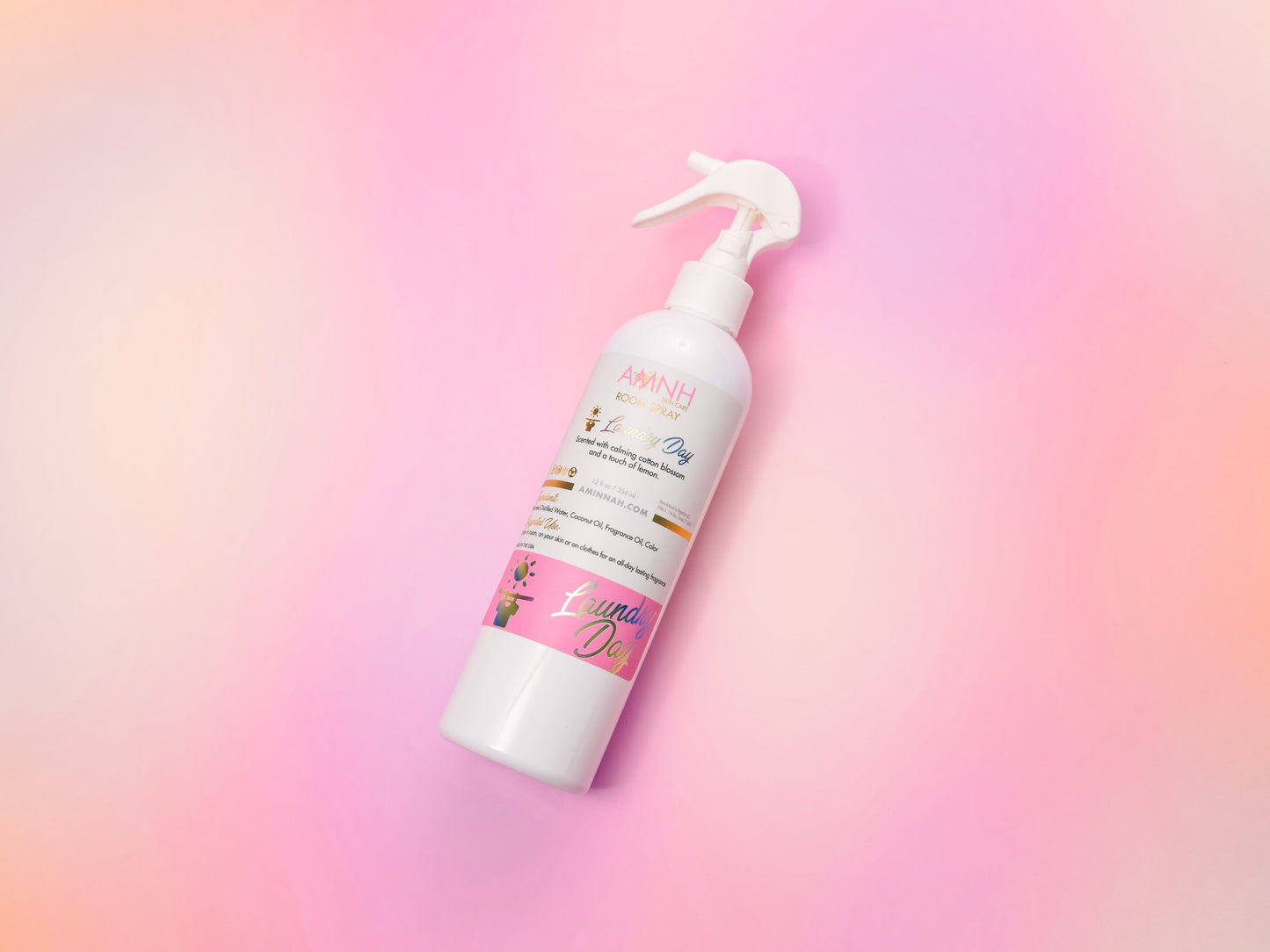 Single room spray bottle tilted on a soft pink gradient.