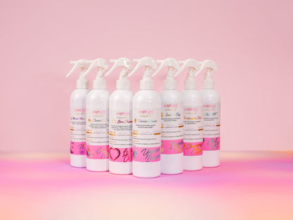 Row of AMNH room spray bottles lined up on pink.