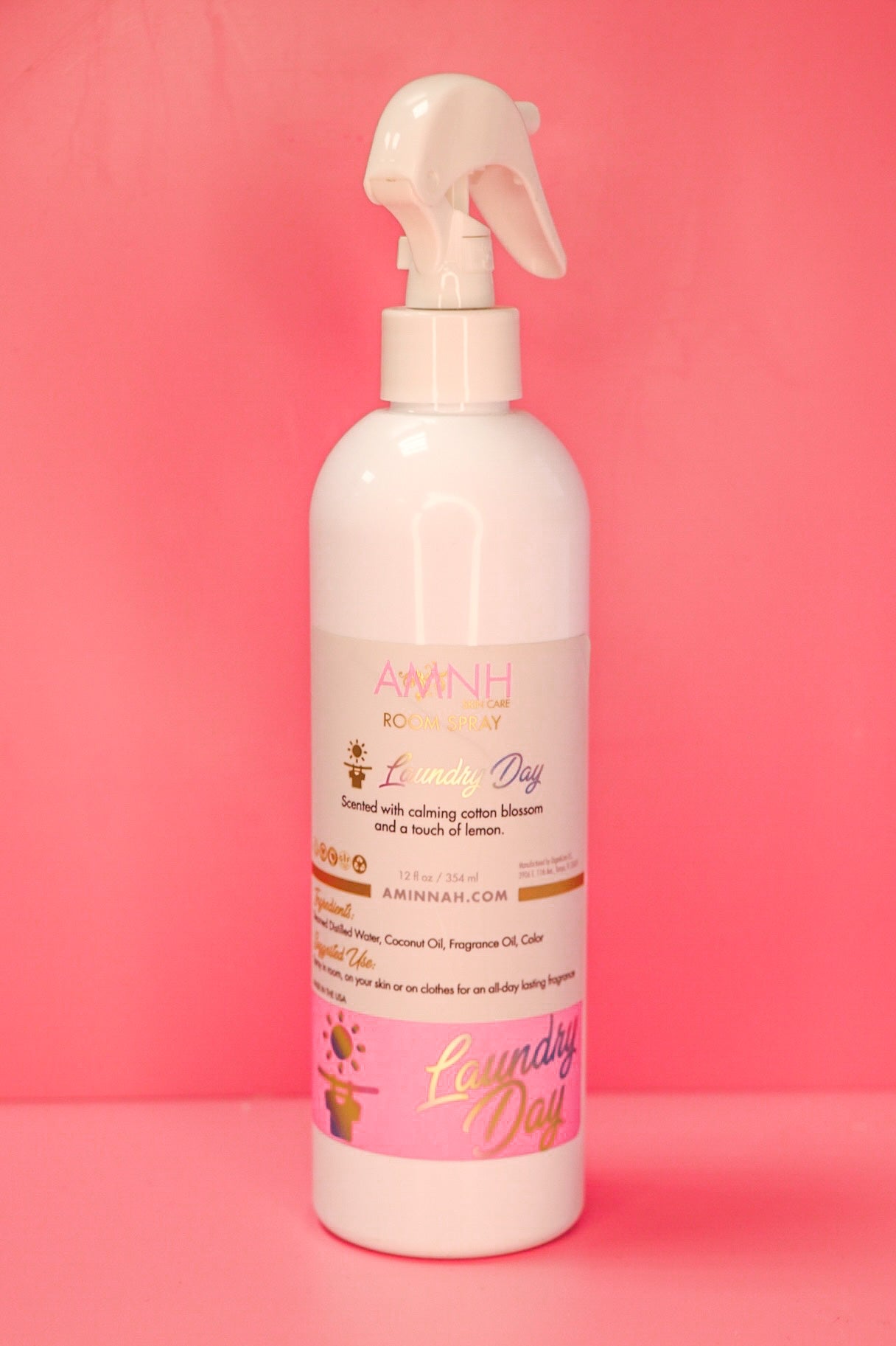 Single room spray bottle standing on a deep pink background.
