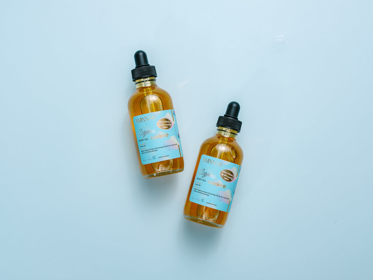 Two body oil bottles lying on a blue background.