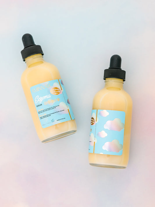 Two dropper bottles of pale yellow serum on a pastel background.
