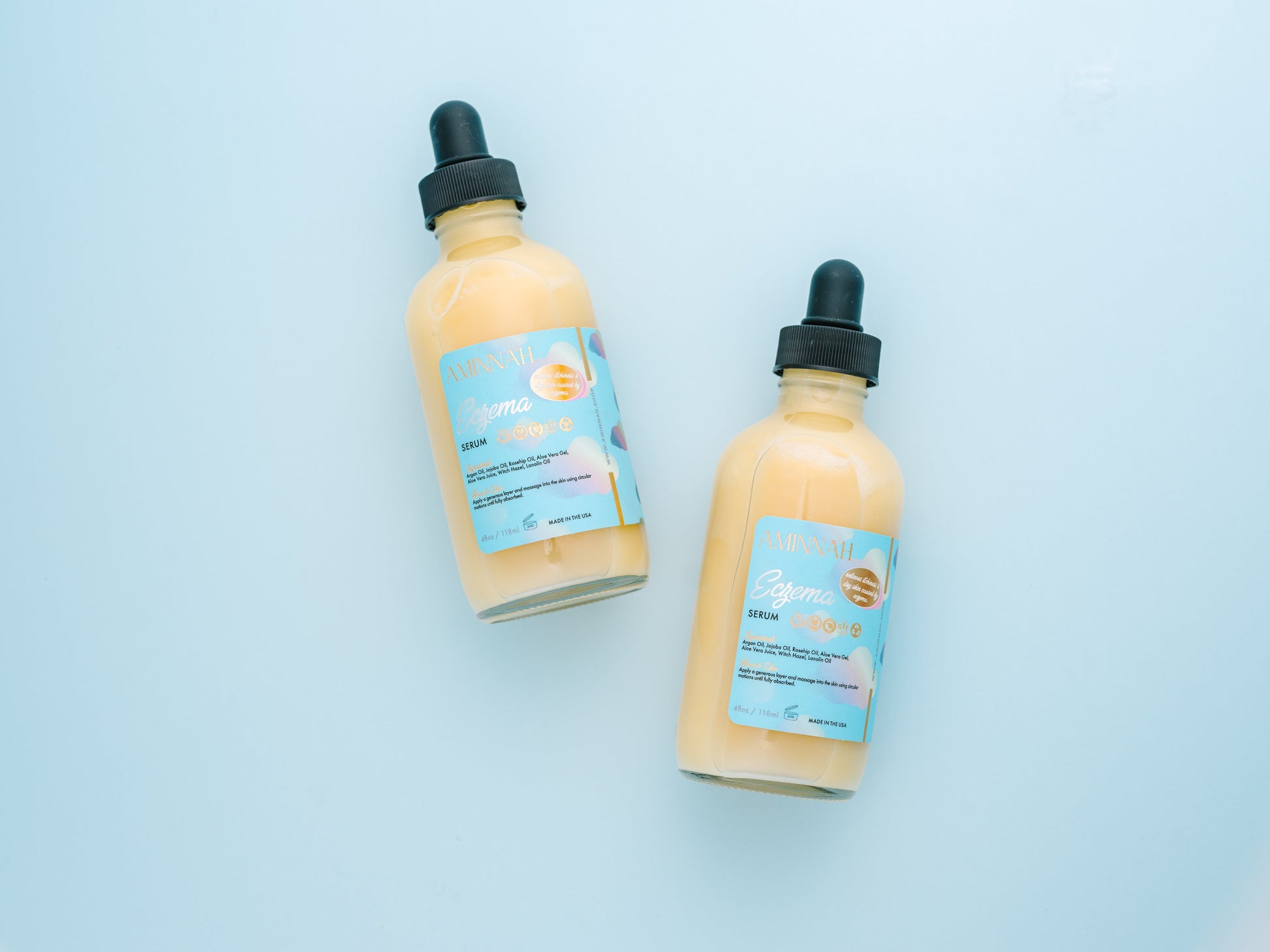Two serum bottles lying on a blue background.