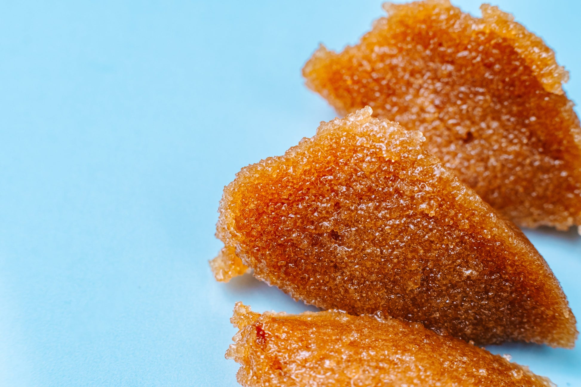 Close view of the wet brown sugar scrub texture on blue.