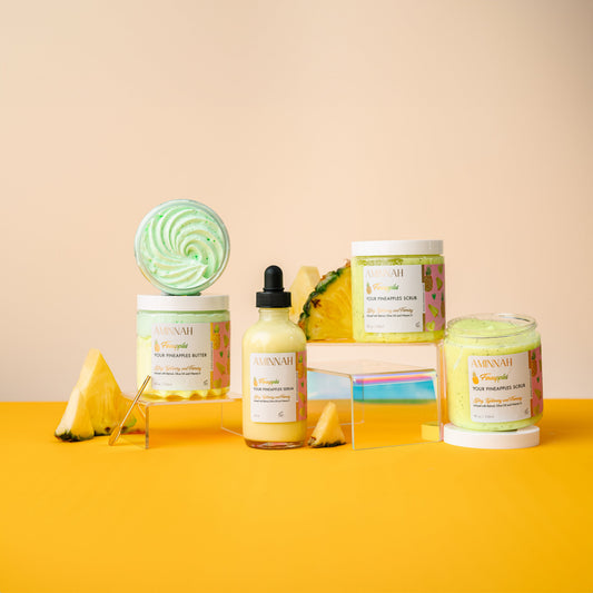 Three Fineapples products standing together with a whole pineapple behind them.
