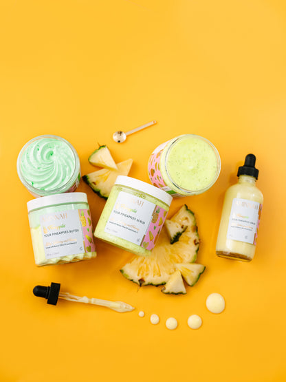Flat lay of two jars and a dropper bottle with pineapple wedges on yellow.