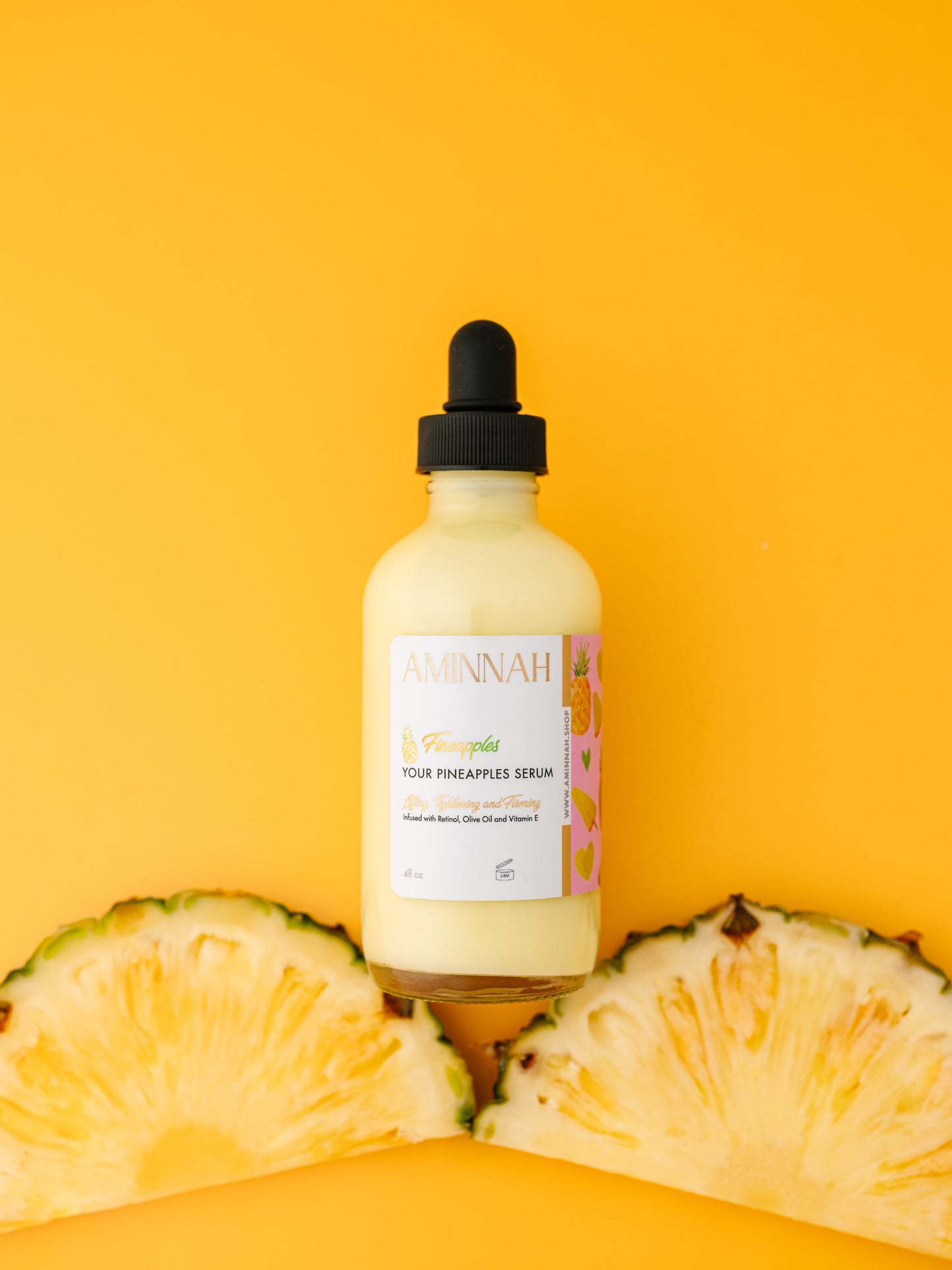 Serum bottle standing upright on a row of pineapple slices.