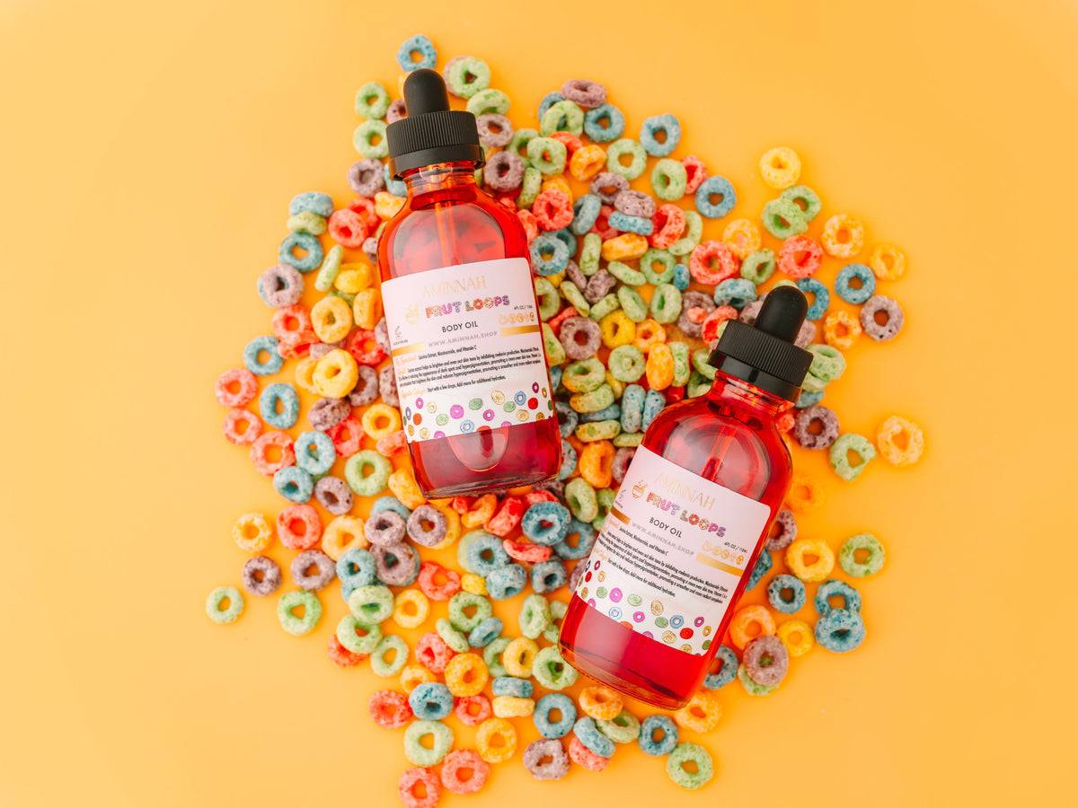 Body oil bottles lying on a scatter of coloured cereal loops.