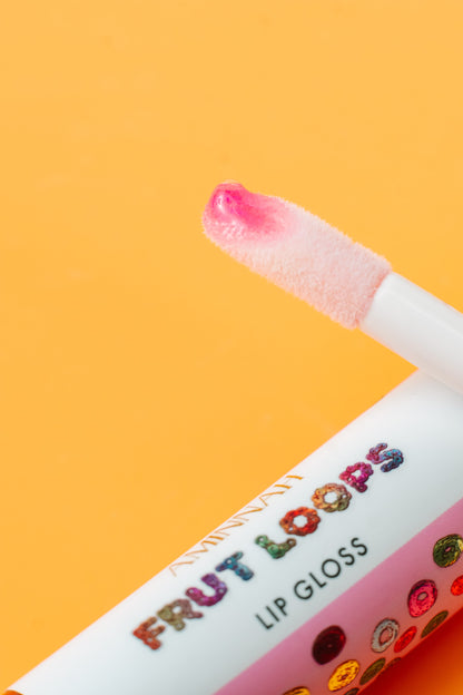 Lip gloss wand lifted from the tube showing the pink gloss.
