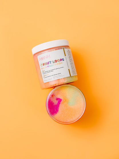 Jar of scrub with a rainbow swirl ball resting beside it on orange.