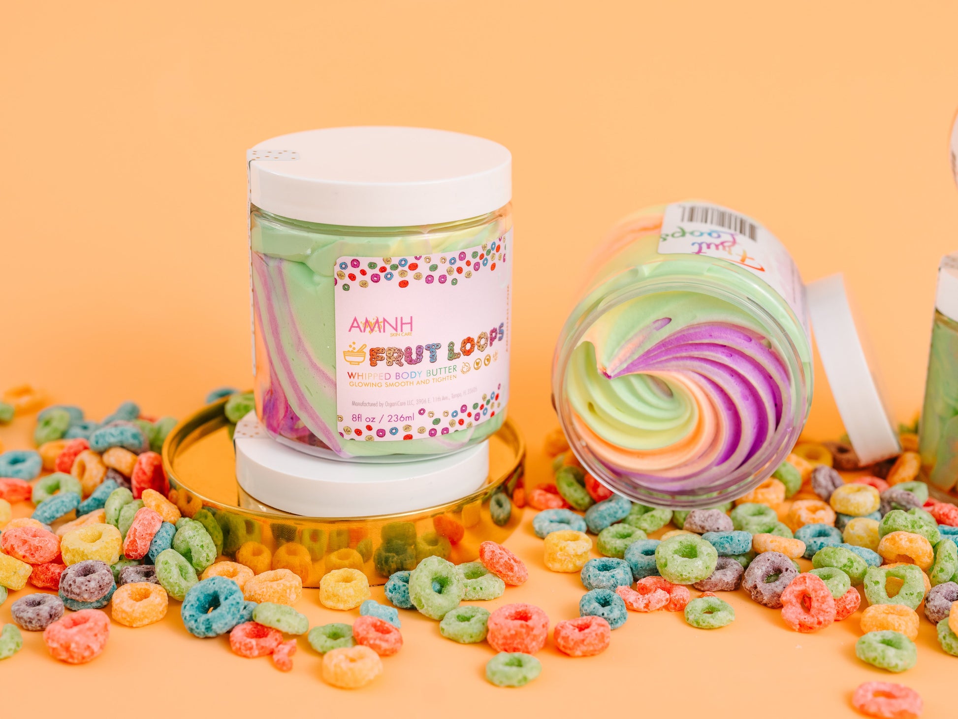 Jar with the lid beside it and cereal loops scattered around, on orange.