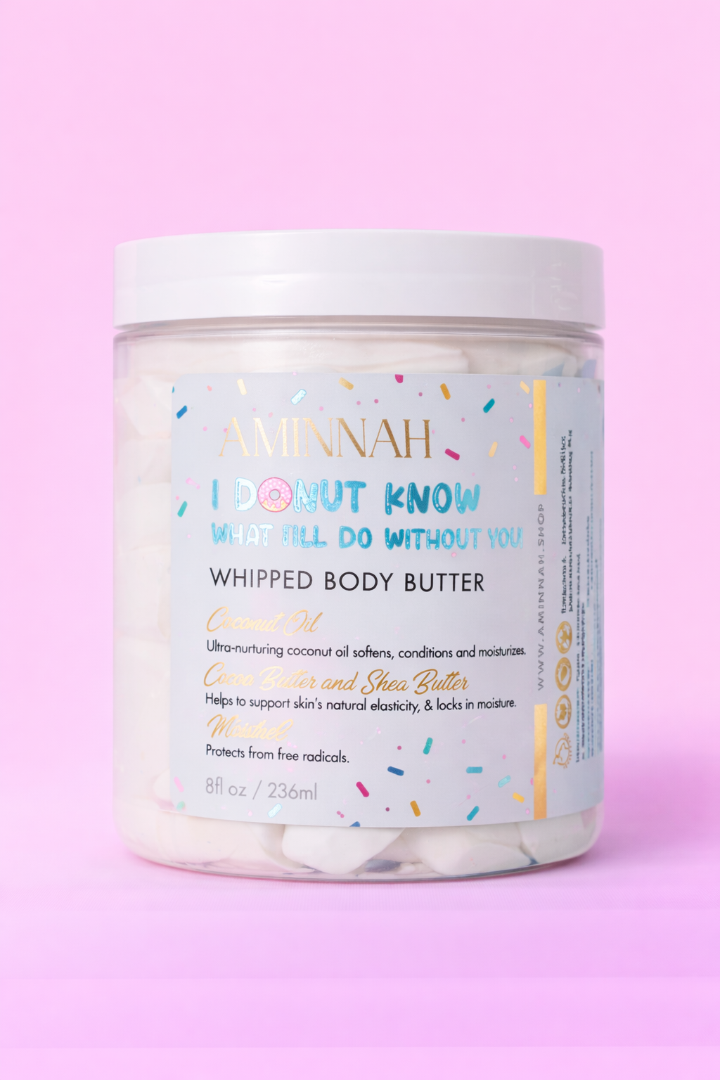 Jar of glazed donut body butter with the label facing forward on pale pink.