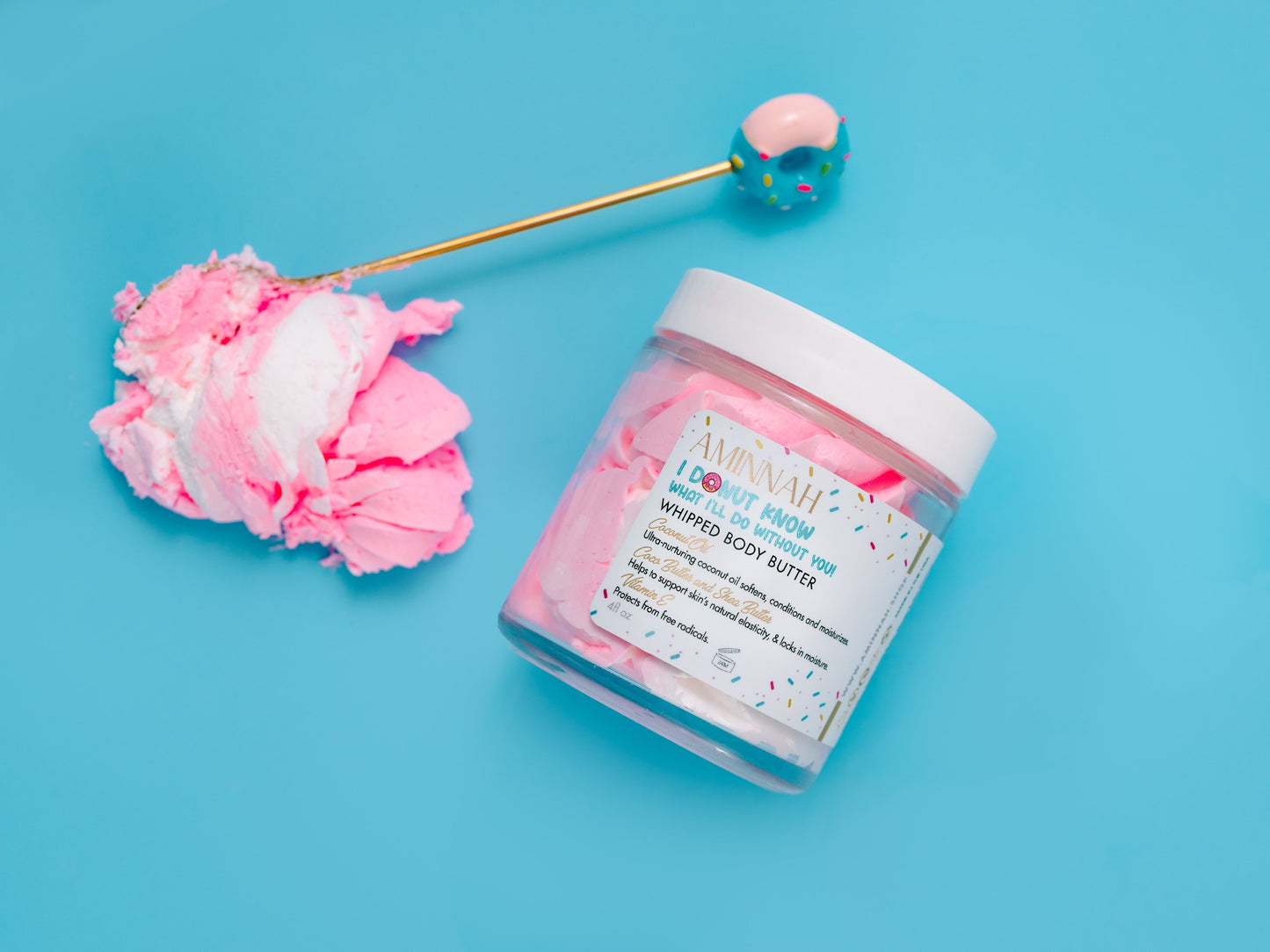 Jar and gold spoon arranged with donut props on a blue background.