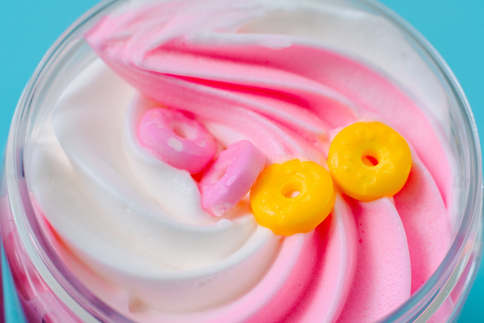 Overhead view of the pink and white whipped swirl with a cereal loop on top.
