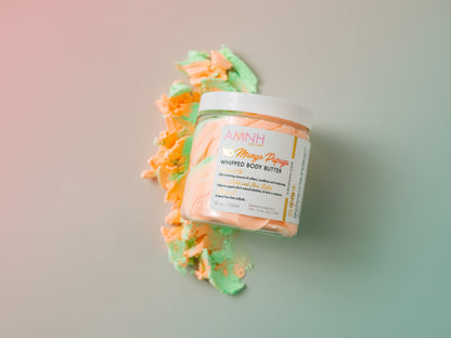 Jar with an orange and cream whipped swirl on a pastel background.
