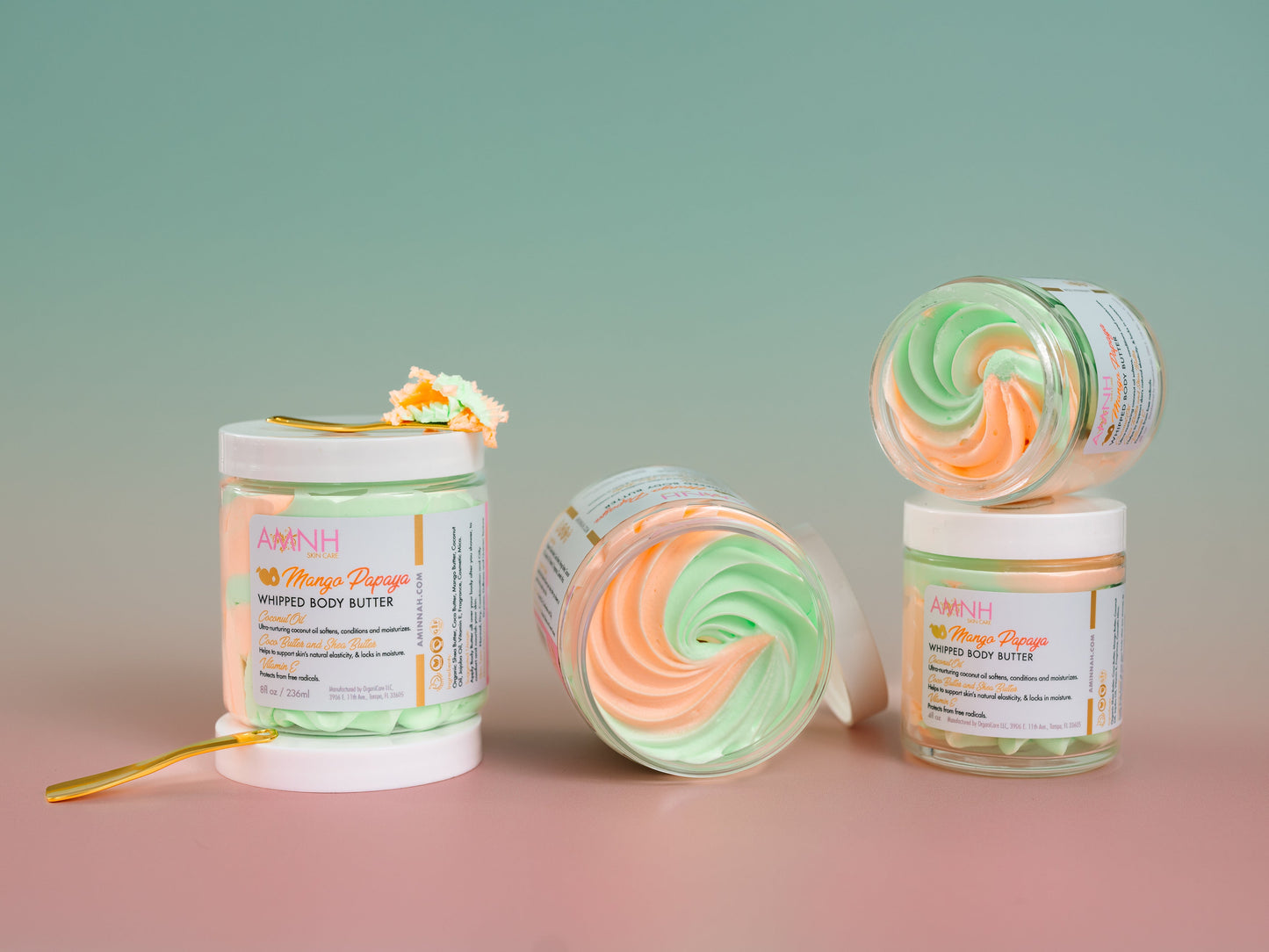 Two jars of whipped butter side by side on a pink and mint background.