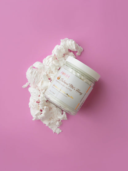Jar with white whipped butter spilling over the rim on a pink background.