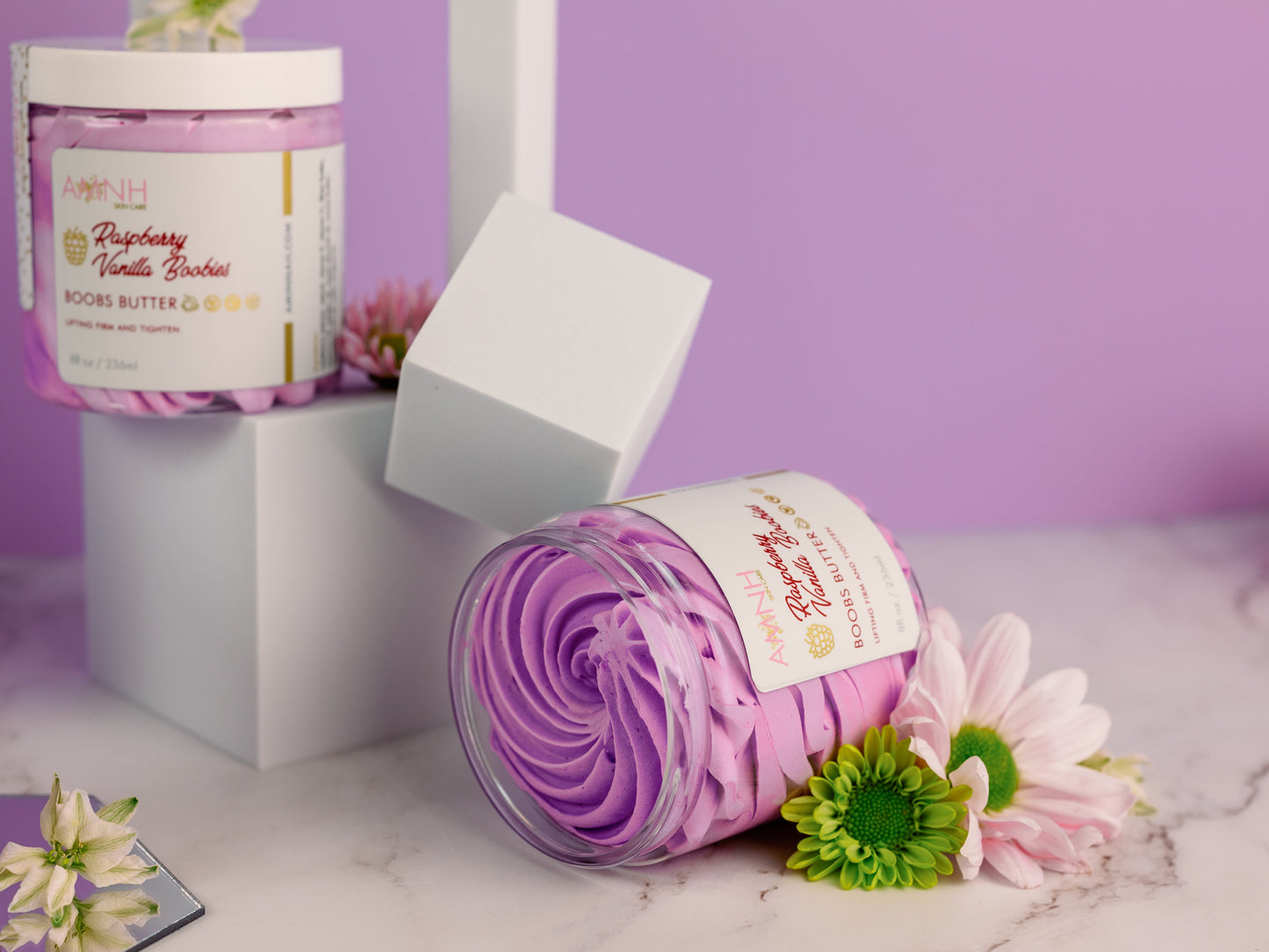Jar with a purple swirl beside a white gift box on lilac.