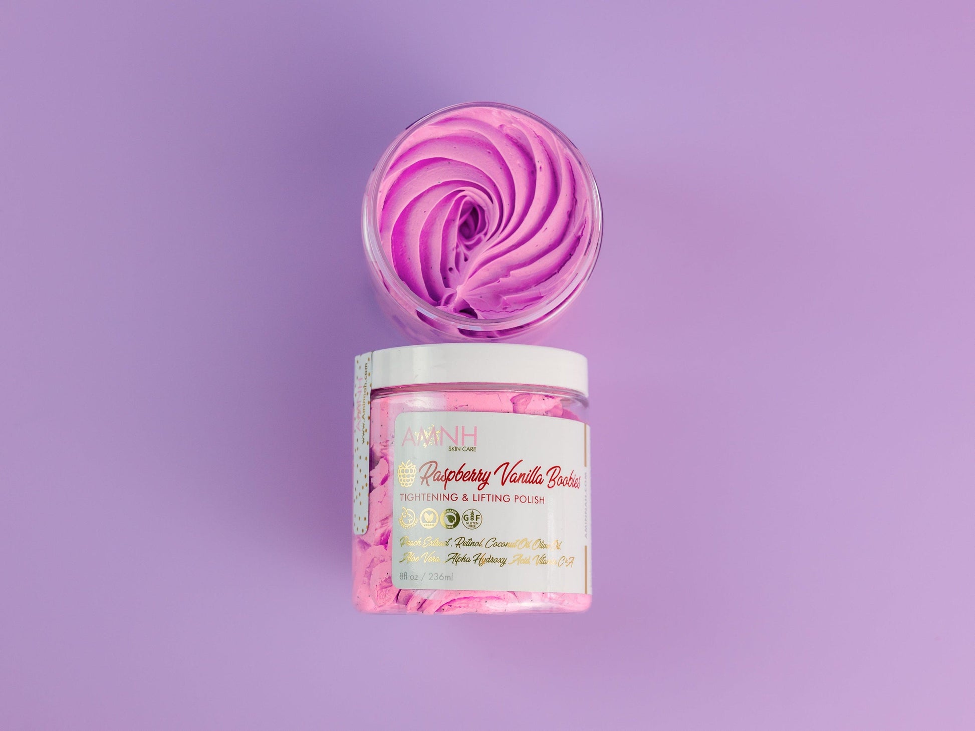Jar of scrub topped with a purple swirl on a lilac background.