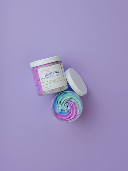 Open jar with a purple whipped swirl and the lid beside it on purple.