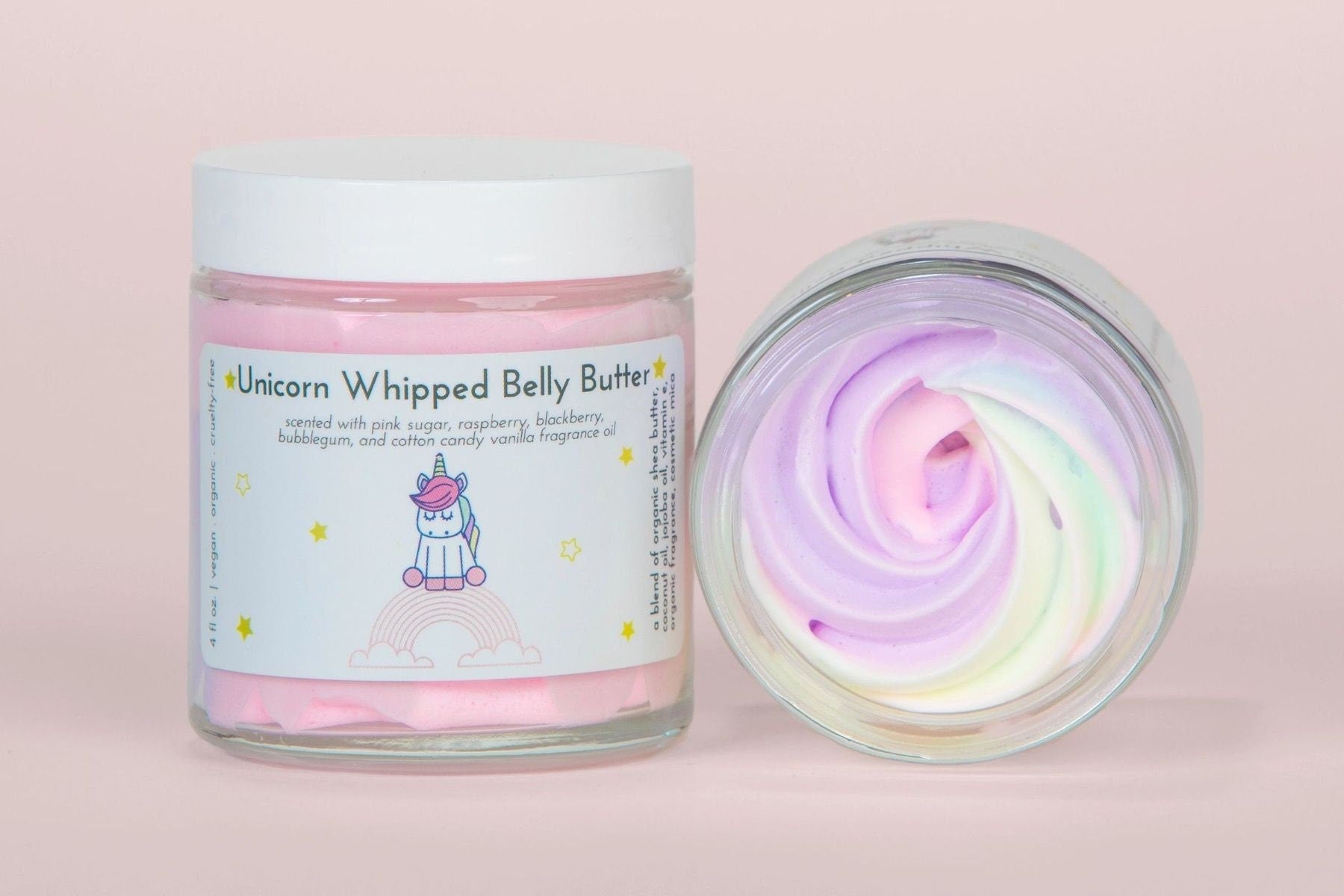 Closed jar beside an open jar showing the rainbow whipped swirl, on pink.