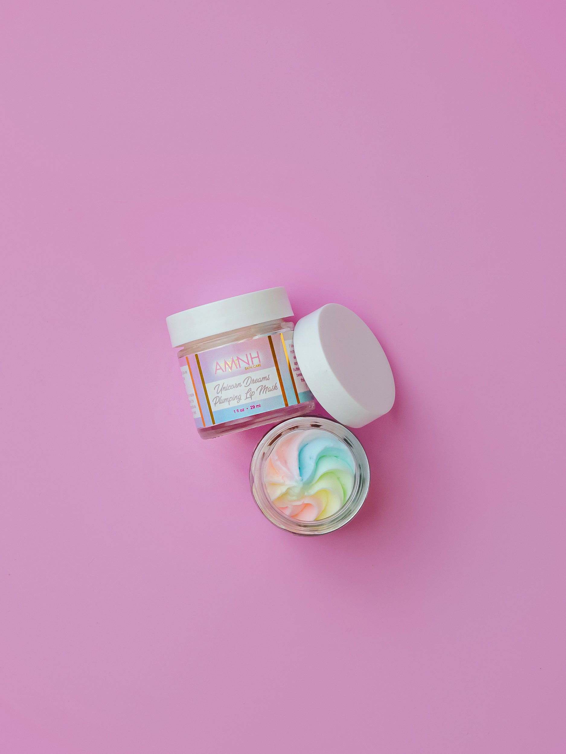 Open jar with a pastel rainbow swirl and the lid beside it on lilac.