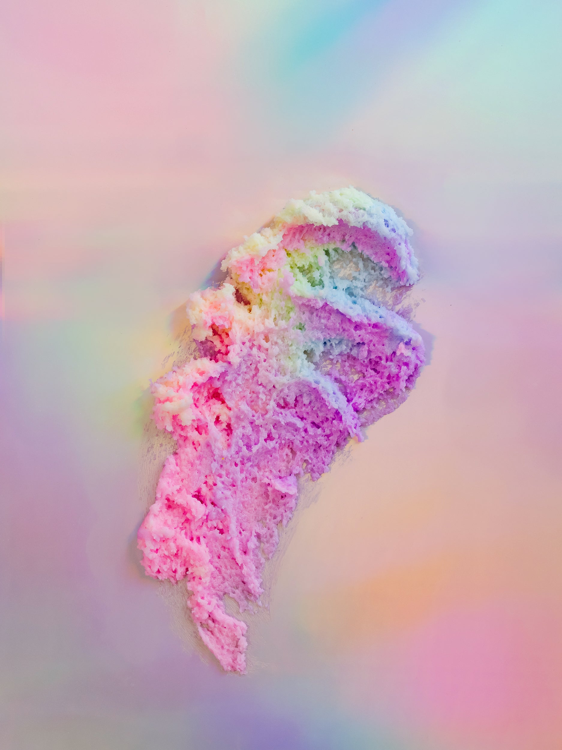 Jar with a pastel scrub swirl spilling beside it on iridescent.