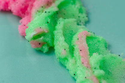 Streak of pink and green sugar scrub across mint.