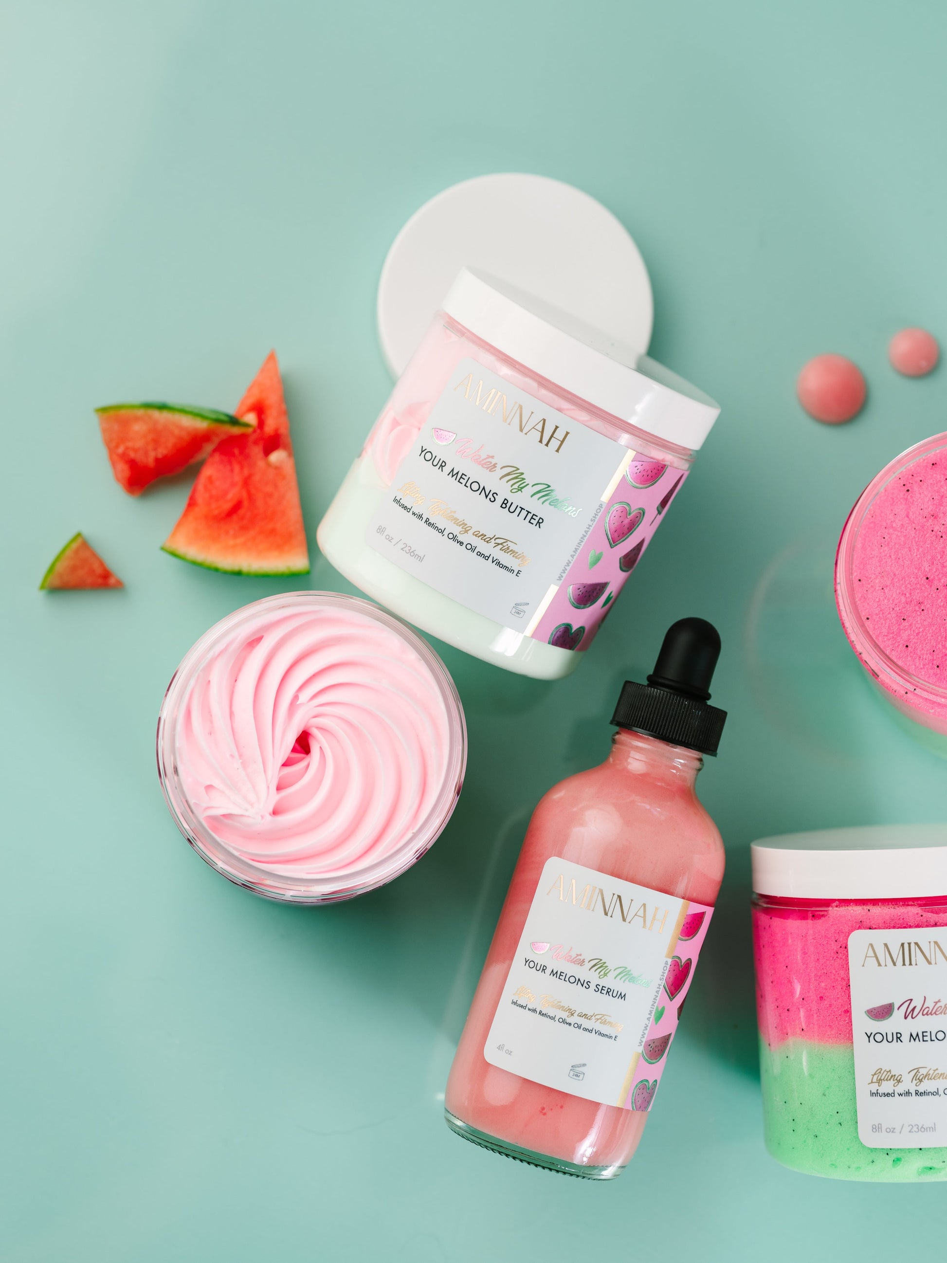 Jar, serum bottle and watermelon pieces arranged on mint.
