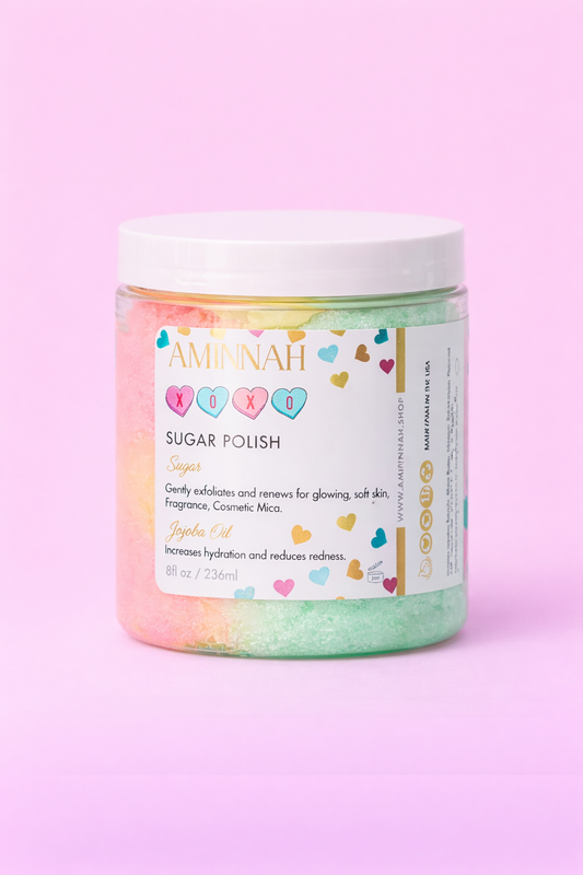 Jar of XOXO sugar scrub with the colourful label facing forward on pale pink.