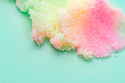 Smear of pink and yellow sugar scrub across a mint background.