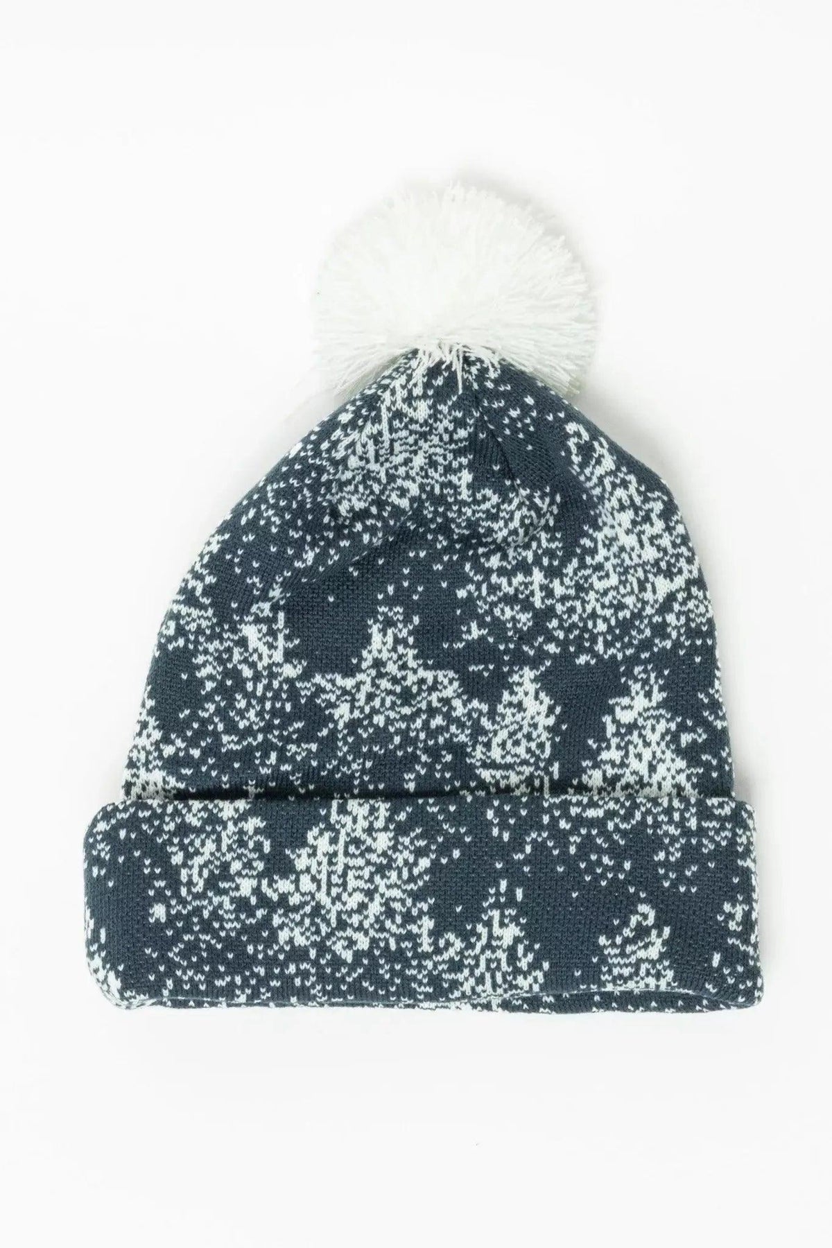 Slate blue knit beanie with a white spruce tree pattern, a cuffed brim and a white pom pom