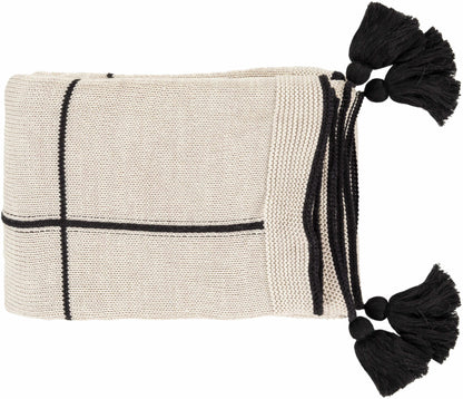 Folded cream knit cotton throw blanket with black grid lines and black tassels at the corners