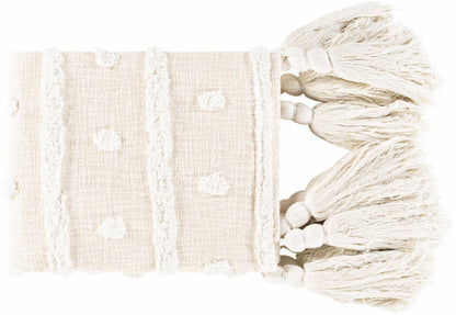 Folded cream throw blanket with tufted dots, raised stripes and a row of big knotted tassels